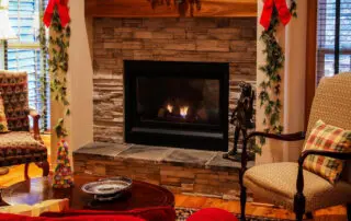 Living room with a stone fireplace decorated for the holidays
