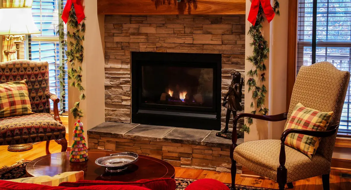 Living room with a stone fireplace decorated for the holidays