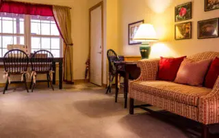 Furnished rental living room with carpet, sofa and dining table
