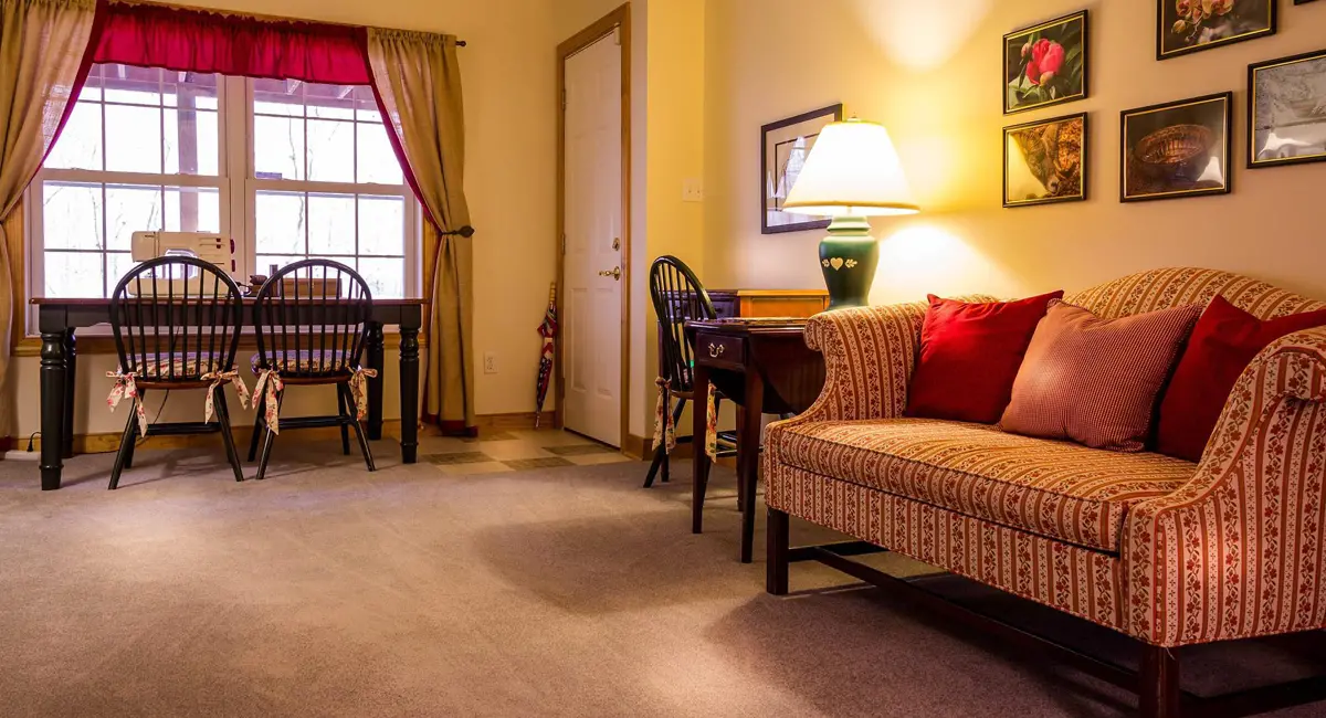 Furnished rental living room with carpet, sofa and dining table