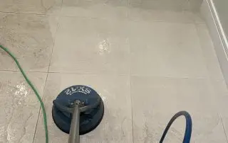 Rotary scrubber cleaning beige bathroom tile