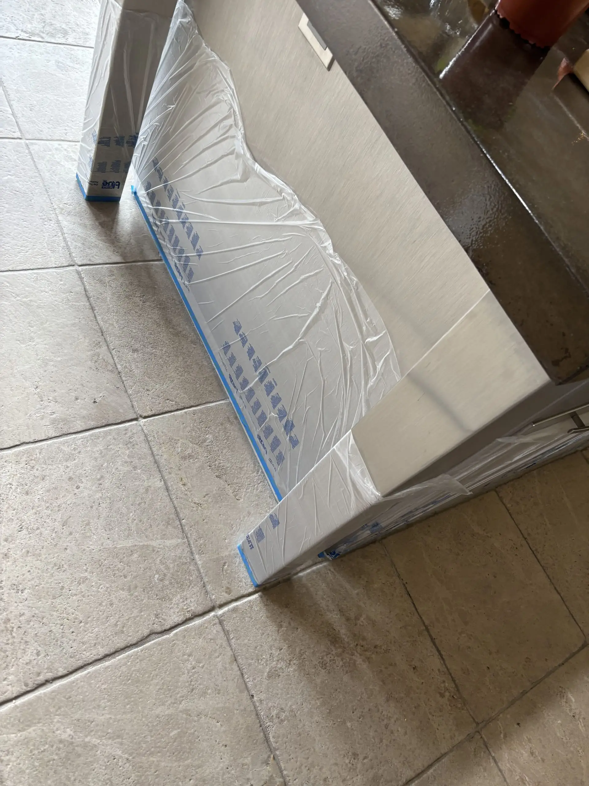 Natural stone floor beside stainless appliances before cleaning