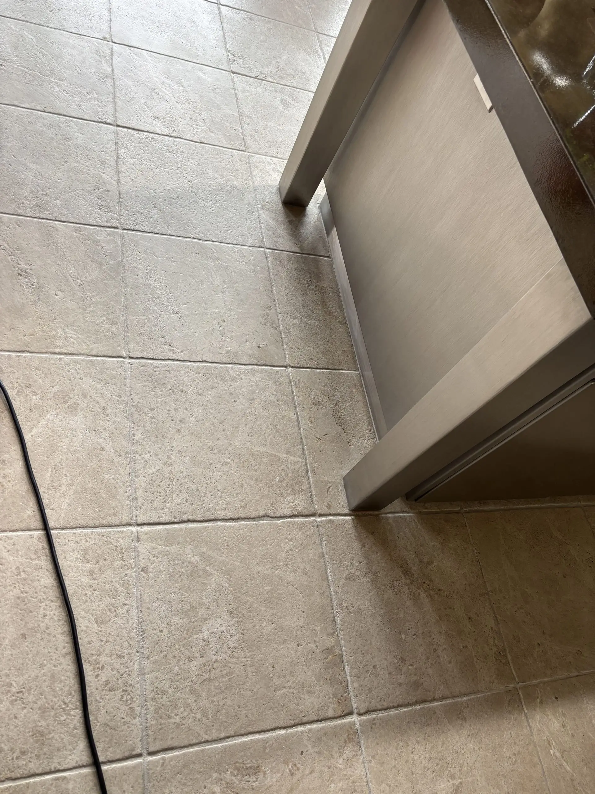 Natural stone floor by a stainless counter after cleaning