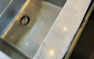 Marble countertop edge beside a sink after clarity polishing