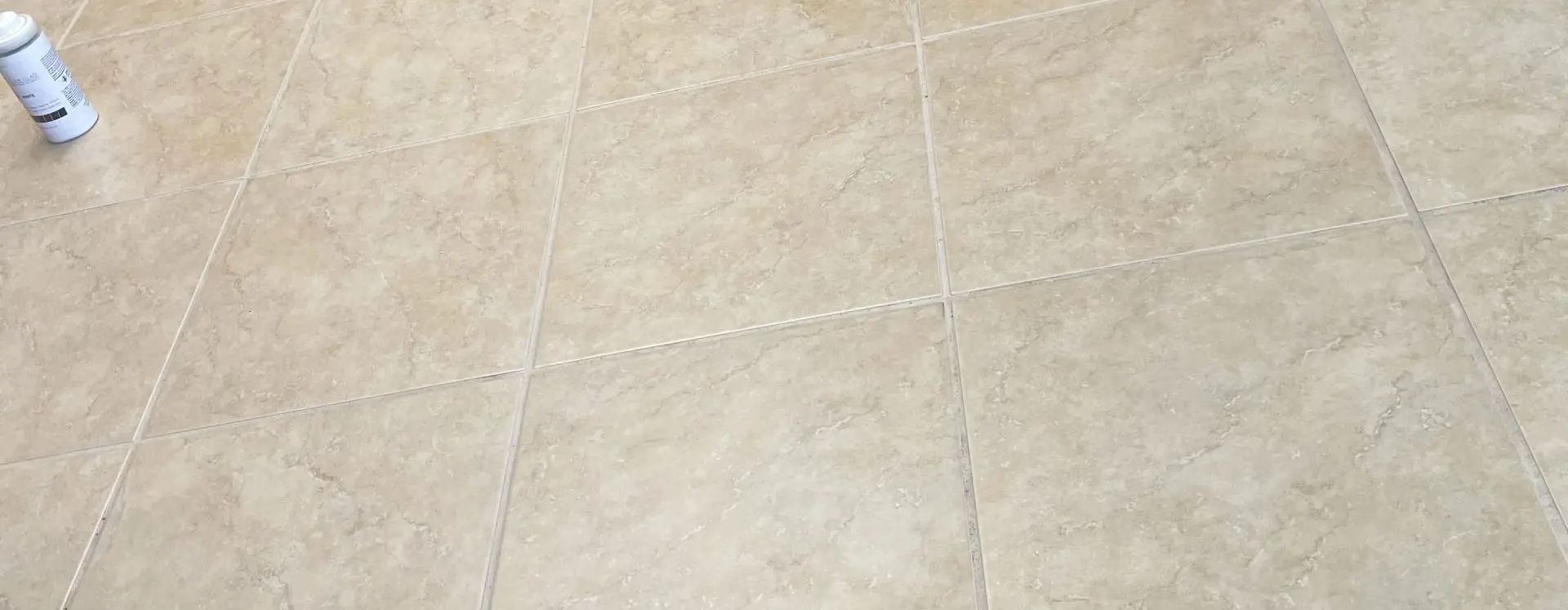 Beige ceramic tile floor with clean, even grout lines after cleaning