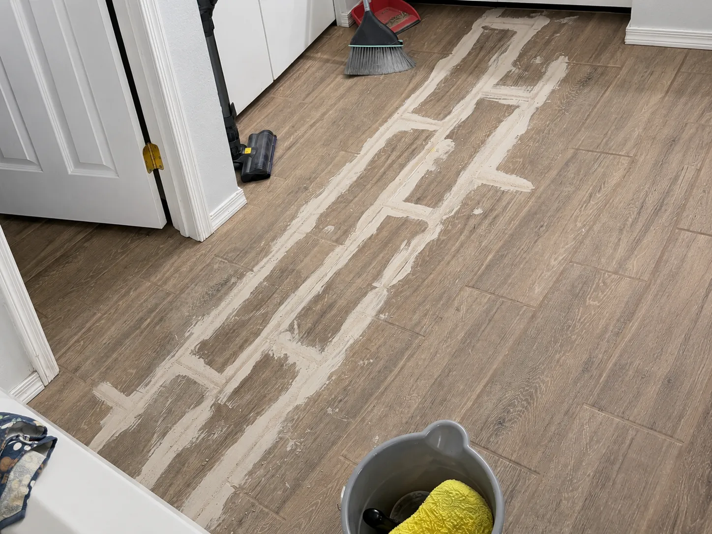 Wood-look tile floor with soiled grout lines before cleaning
